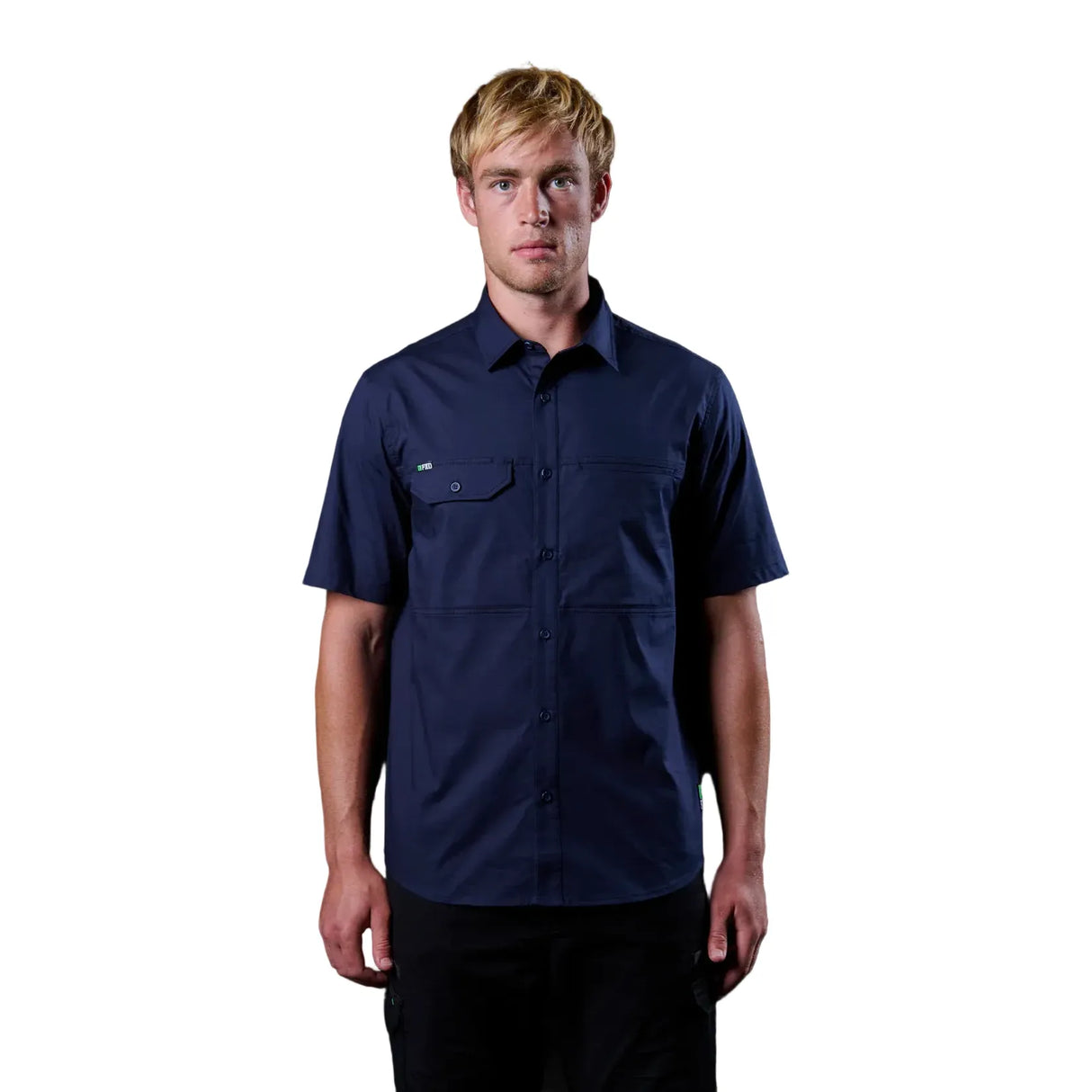 Man wearing a navy blue short-sleeve shirt against a black background