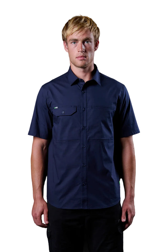 Man wearing a navy blue short-sleeve shirt against a black background